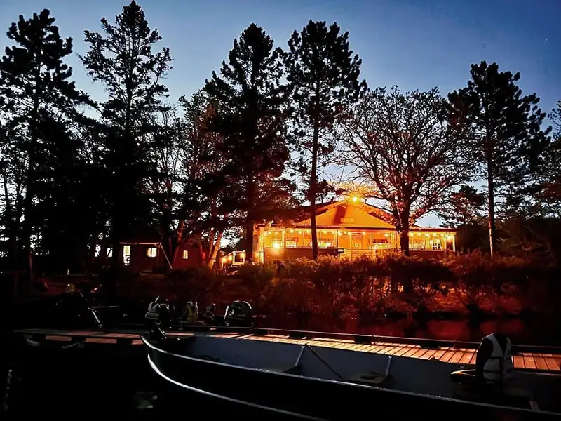 Sunset at Grassy Narrows Lodge Waterfront cabins and boats at Grassy Narrows Lodge during sunset in Miles Bay.