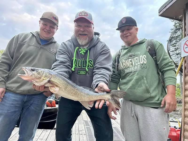 Returning Guests with Walleye Catch Returning guests celebrate a successful walleye catch at Grassy Narrows Lodge.
