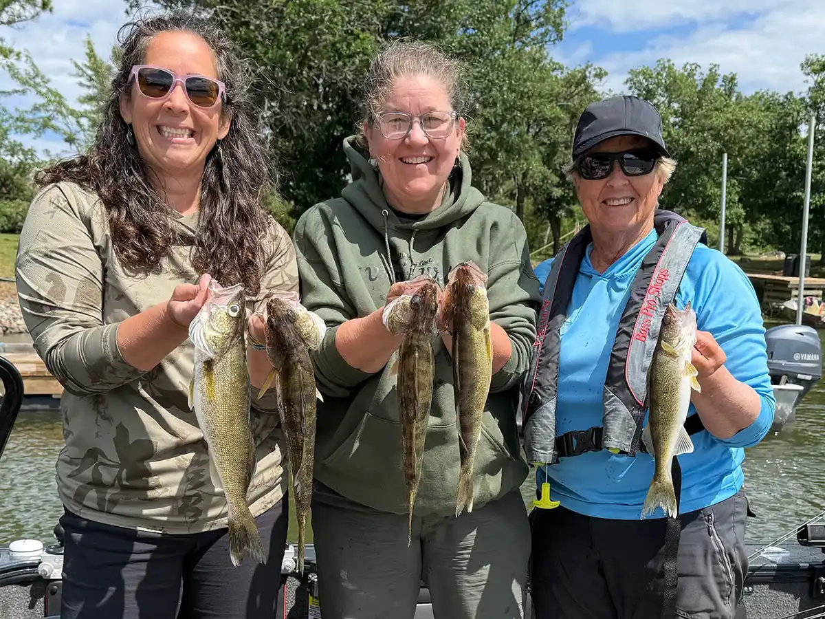 Women holding walleye during Women's Week at Grassy Narrows Lodge