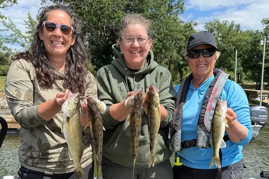 Three anglers showing their catch during a fishing trip at Grassy Narrows Lodge